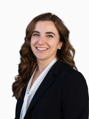 Smiling woman in black blazer and white blouse against white background