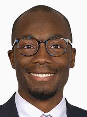 Runsewe Oluwapeyibomi smiling headshot wearing glasses and a suit