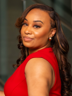 Woman in red sleeveless dress glancing over her shoulder with a slight smile