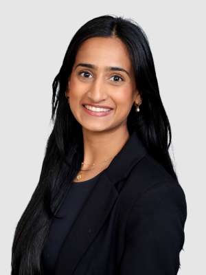 Woman in black blazer smiling in professional headshot