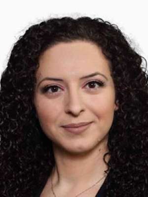 Paytsar Topchyan, headshot of a woman with dark curly hair and neutral expression.