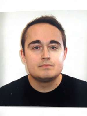 Passport-style headshot of a man with short dark hair facing camera