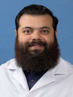 Christofer Bello, MD in a white lab coat