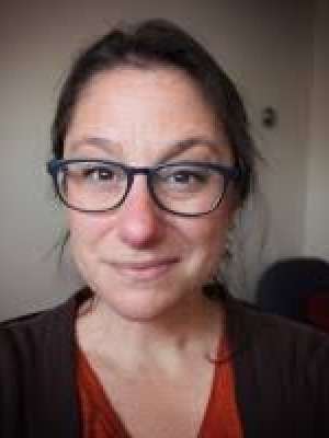 Headshot of woman wearing glasses smiling at camera
