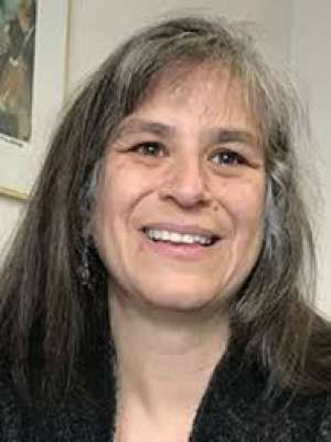 Smiling woman with long dark hair and gray streaks