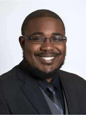 Smiling man in suit and tie wearing glasses, professional headshot