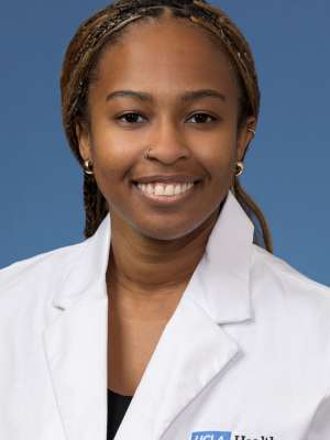 Head shot of Angela Udongwo, MD, MPH, in white coat, smiling at camera
