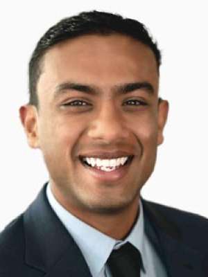 Smiling young man headshot wearing suit and tie