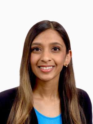 Smiling woman headshot with long brown hair, black blazer and blue top