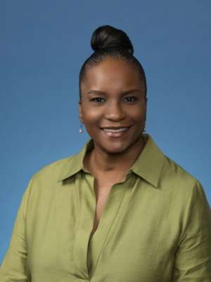 Woman wearing a green shirt against a blue background.