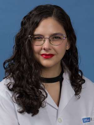 Head shot of Sama Elrahi in white lab coat, smiling at camera