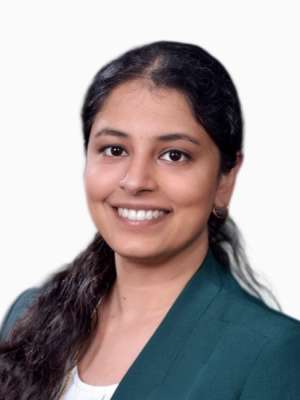 Professional headshot: smiling woman in green blazer and white top