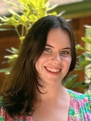 Smiling woman with dark hair in a floral top outdoors