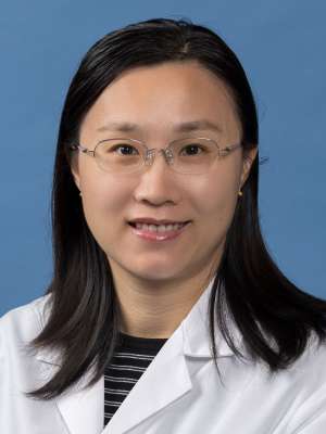 Qing Emily Hu, PhD in a white lab coat