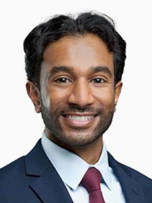 Smiling professional headshot of a man in a suit and tie