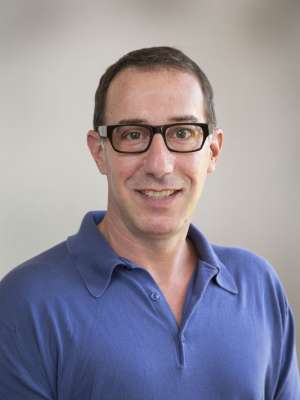 David Eisenman, MD headshot wearing glasses and blue shirt, smiling