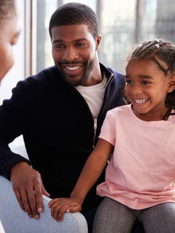Father And Daughter Having Consultation With Pediatrician In Hospital Office