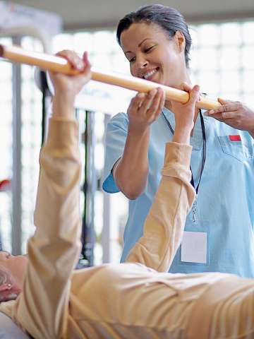Nurse Helping Middle Aged Woman with Physical Therapy