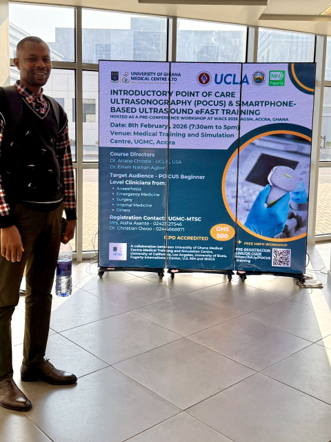 A man stands in front of a sign in a hospital.