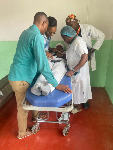 Doctors stand around a patient in a hospital bed.
