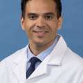 White coat head shot of Christopher Hernandez, smiling at the camera