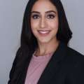 Headshot of Simrat in a black suit with pink shirt