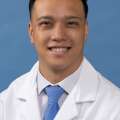 White coat head shot of Michael Arias, smiling at the camera