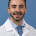 White coat head shot of Borja Sanz Cuesta, smiling at the camera