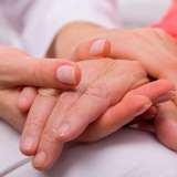 Holding elderly patient's hand