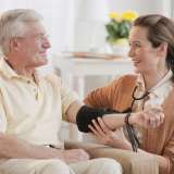 Nurse taking senior man's blood pressure