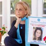 Paulinda Schimmel Babbini sitting on a porch, holding a photo of her daughter.
