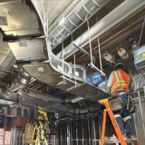 A crew member installs the HVAC system at Mid-Wilshire