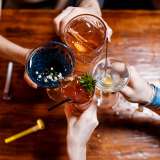 People holding up glasses of alcohol in celebration.