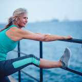 A senior woman stretches as part of her exercise.