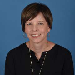 Headshot of libby shin in black blouse