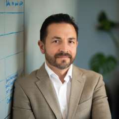 Dr. Benjamin Ellingson standing with his arms folded and looking at the camera