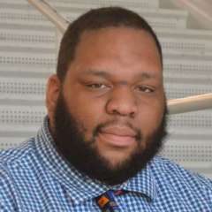 headshot of Anthony jones in a blue plaid shirt