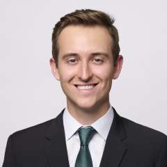 Head shot of Dr. Brendan Colgan in a suit, smiling at the camera