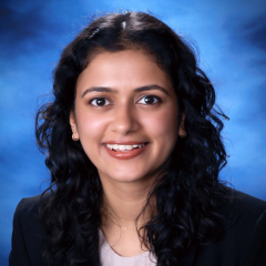 Head shot of Anjali Upadhyaya in business attire, smiling at camera