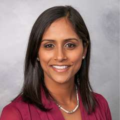 headshot of Nikita baclig in burgundy blouse