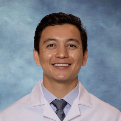 A headshot of a Dr. Michael LoBasso with dark hair, and a warm smile, wearing a white coat and a tie.