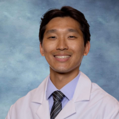 headshot of Dr. Christopher Yoon wearing a labcoat in front of a blue background