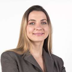 Headshot of Tatiana Diacova wearing a grey blazer