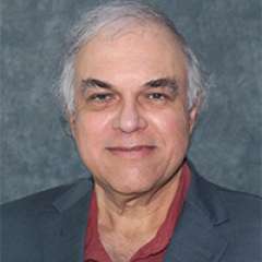 headshot of Dr. Jose Escarce in a grey suit and burgundy shirt