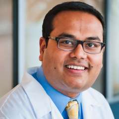 Headshot of Aditya Bardia, MD, MPH, in a white coat and tie.