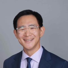 Head shot of Jerry Shen in business attire, smiling at camera