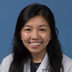 Head shot of Elaine Ramirez in white lab coat, smiling at camera