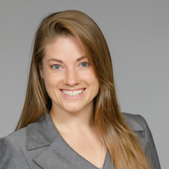 Head shot of Neva Lundy in business attire, smiling at camera
