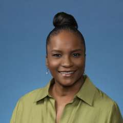 Woman wearing a green shirt against a blue background.