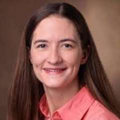 headshot of Carrie Wiese in a salmon colored shirt